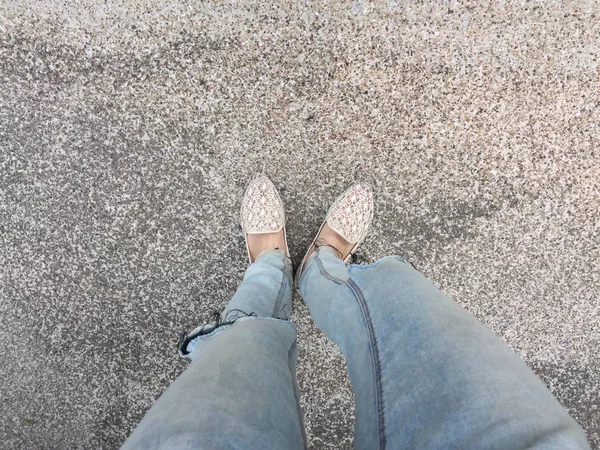 Primer plano de los pies de la muchacha que usa sandalias de tejido en el suelo —  Fotos de Stock