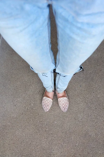 Primer plano de los pies de la muchacha que usa sandalias de tejido en el suelo —  Fotos de Stock