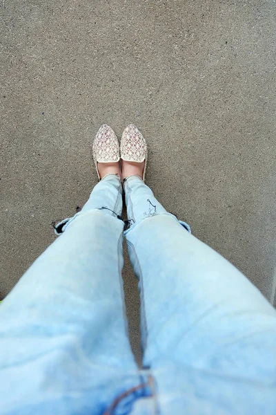 Primer plano de los pies de la muchacha que usa sandalias de tejido en el suelo —  Fotos de Stock