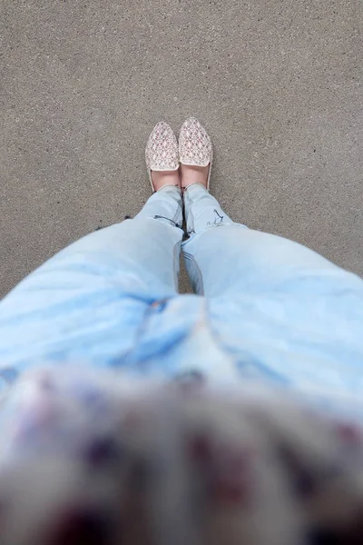关闭了女孩的脚在地上穿编织凉鞋 — 图库照片