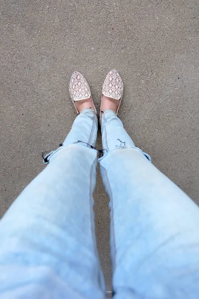 Primer plano de los pies de la muchacha que usa sandalias de tejido en el suelo — Foto de Stock