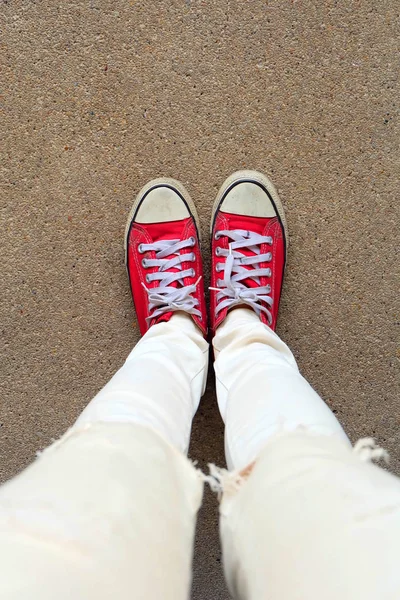 Selfie Feet indossa scarpe da ginnastica rosse sullo sfondo del pavimento in cemento — Foto Stock