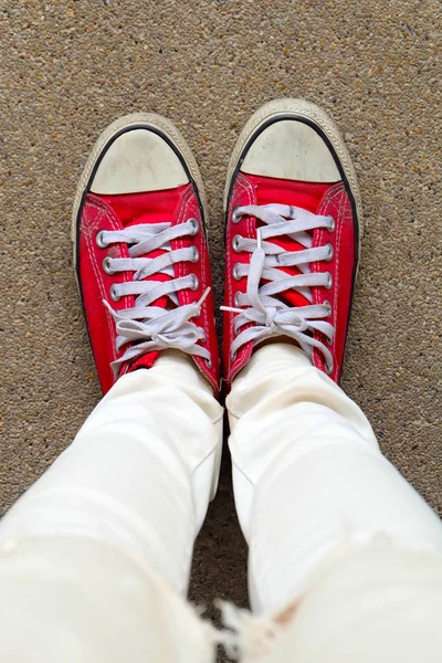 Selfie Feet portant des baskets rouges sur le fond de plancher en béton — Photo
