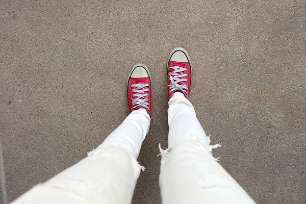 Selfie pés vestindo tênis vermelhos no fundo do piso de concreto — Fotografia de Stock