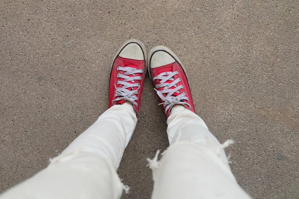 Selfie πόδια φοράει κόκκινα αθλητικά παπούτσια στο τσιμεντένιο πάτωμα φόντο — Φωτογραφία Αρχείου