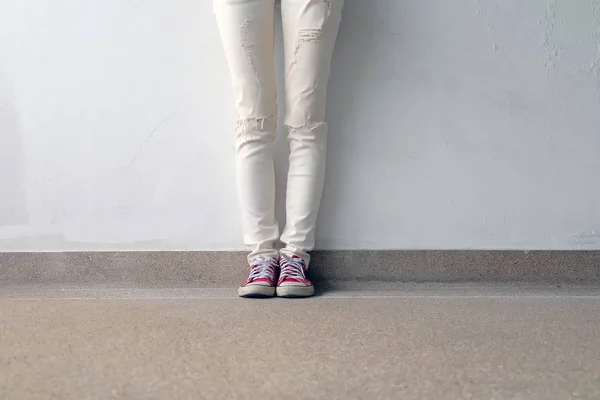 Foto de primer plano de una mujer que usa zapatillas rojas en el fondo de hormigón —  Fotos de Stock