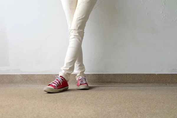 Närbild foto av från kvinna som bär röda Sneakers på betonggolv bakgrunden — Stockfoto