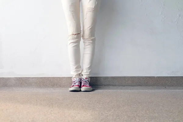 Foto de primer plano de una mujer que usa zapatillas rojas en el fondo de hormigón —  Fotos de Stock