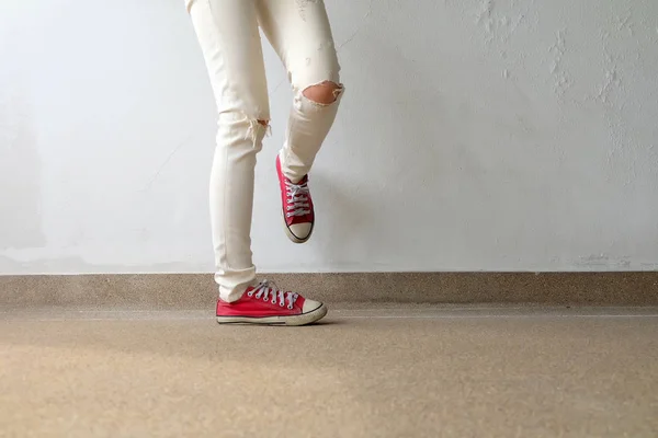 Nahaufnahme von einer Frau, die rote Turnschuhe auf dem Betonboden trägt — Stockfoto