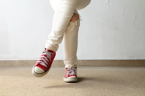 Foto de primer plano de una mujer que usa zapatillas rojas en el fondo de hormigón —  Fotos de Stock