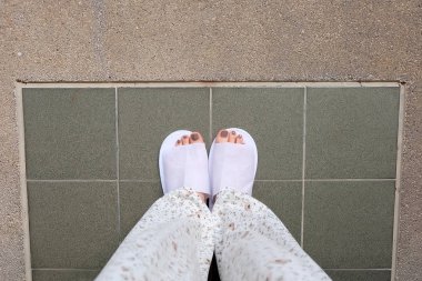 Selfie ayakları yere beyaz terlik kapalı giyiyor 