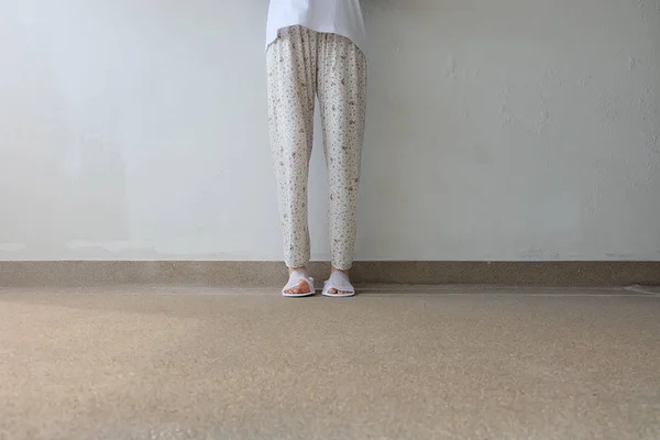 Φωτογραφία: closeup από γυναίκα πόδια φορώντας λευκό παντόφλες εσωτερικούς χώρους στο έδαφος — Φωτογραφία Αρχείου