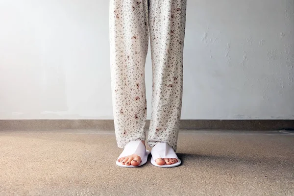 Kadın ayakları yere beyaz terlik kapalı giyiyor, closeup fotoğraf — Stok fotoğraf