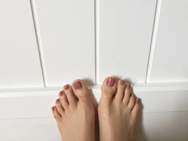 Vrouwelijke voeten met Brown Nail opzoeken, verhoogd rechte omhoog in de slaapkamer — Stockfoto