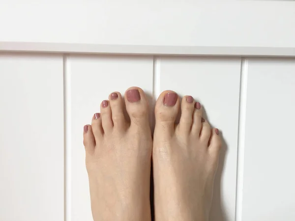 Vrouwelijke voeten met Brown Nail opzoeken, verhoogd rechte omhoog in de slaapkamer — Stockfoto