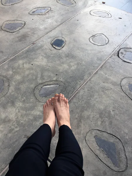 Крупним планом дівчина босоніж на бетонній кам'яній плитці підлозі — стокове фото