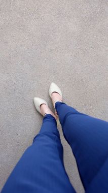 Kadın bacaklar yüksek topuk altın sandalet Stand yerde, açık arka plan