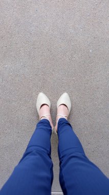 Kadın bacaklar yüksek topuk altın sandalet Stand yerde, açık arka plan