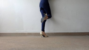 Kadın bacaklar yüksek topuk altın sandalet Stand yerde, açık arka plan