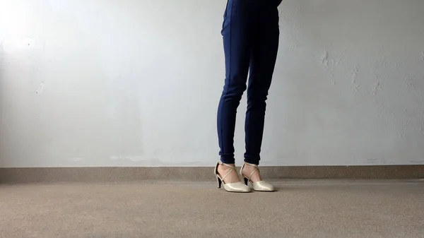 Kadın bacaklar yüksek topuk altın sandalet Stand yerde, açık arka plan — Stok fotoğraf