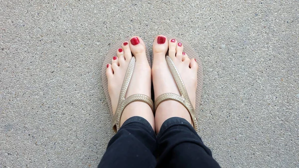 Close Up on Girl 's Feet vestindo sandálias de ouro no fundo do solo — Fotografia de Stock