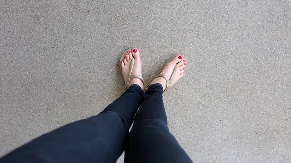 Close Up on Girl 's Feet Wearing Golden Sandals on Ground Background — стоковое фото