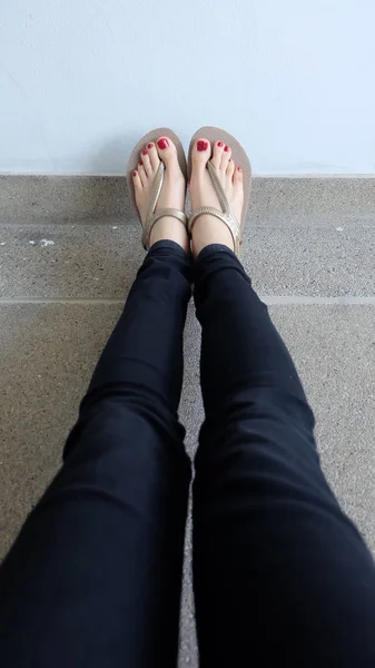 Крупним планом на Дівчата ноги носити золоті сандалі на землі — стокове фото
