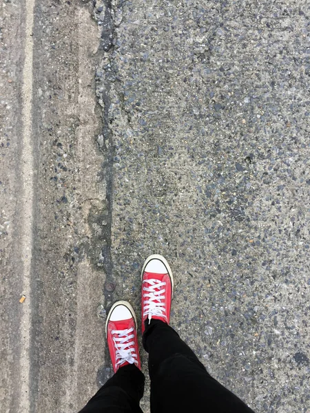 Närbild foto av från kvinna som bär röda Sneakers på betonggolv bakgrunden — Stockfoto