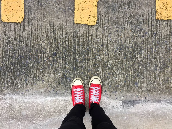 Крупним планом Фотографія від жінки в червоних кросівок на фоні бетонної підлоги — стокове фото