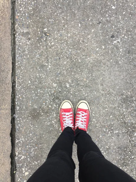 从女人穿着红色运动鞋上混凝土楼板背景的特写照片 — 图库照片