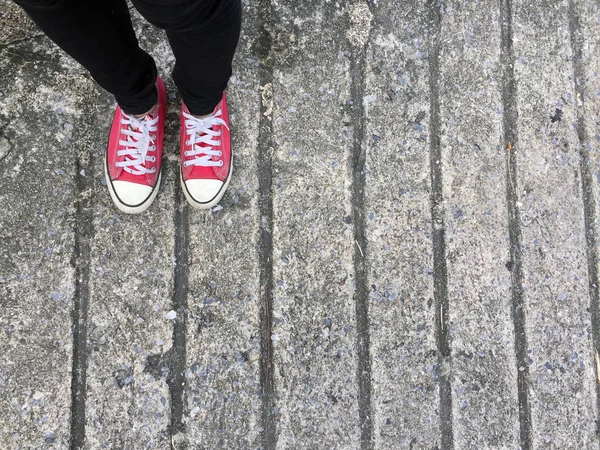 Närbild foto av från kvinna som bär röda Sneakers på betonggolv bakgrunden — Stockfoto