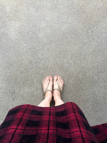 Primer plano en las sandalias de niña y vestido rojo en la calle — Foto de Stock