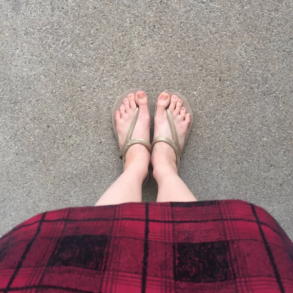 Close Up na nošení dívčí sandály a červené šaty na ulici — Stock fotografie