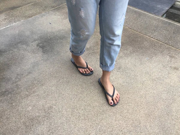 Close Up on Girl 's Feet vestindo sandálias pretas e jeans azuis na rua — Fotografia de Stock