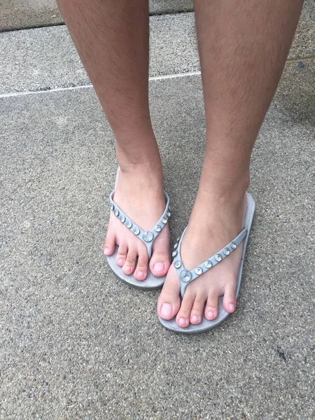 Female feet wear Gray Sandal on the Street