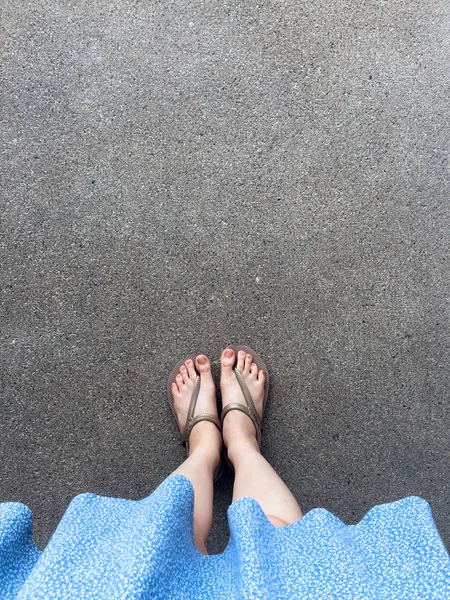 Female Feet Wear Sandals and Blue Dress on the Street