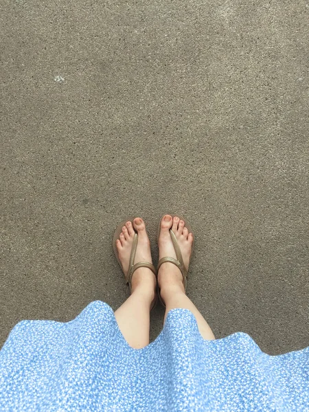 Female Feet Wear Sandals and Blue Dress on the Street