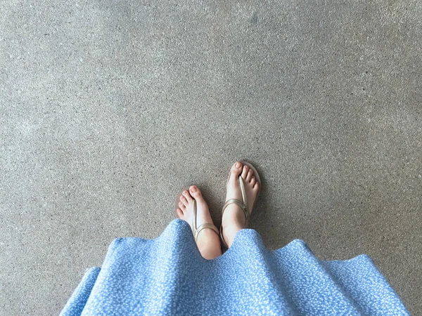 Female Feet Wear Sandals and Blue Dress on the Street