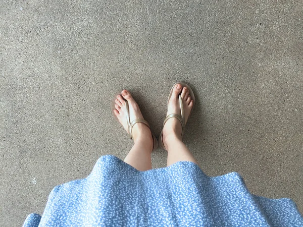 Female Feet Wear Sandals and Blue Dress on the Street