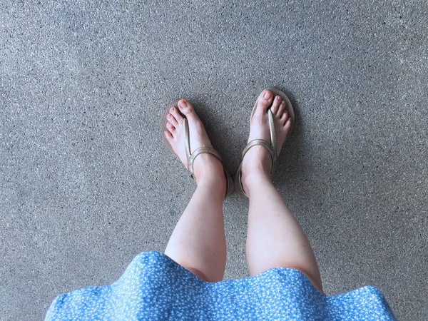 Female Feet Wear Sandals and Blue Dress on the Street