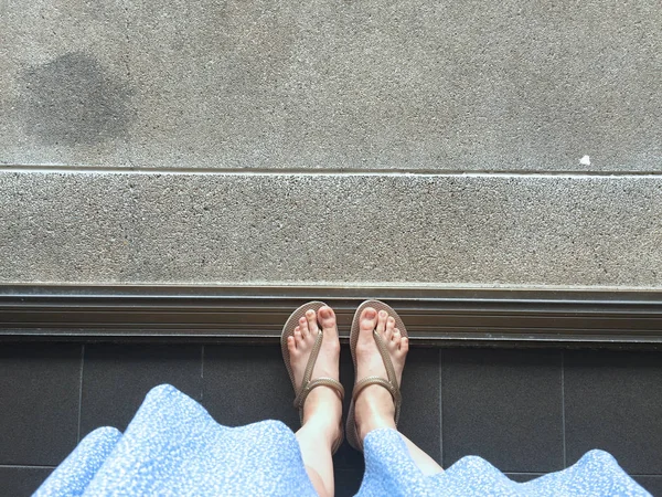 Female Feet Wear Sandals and Blue Dress on the Street