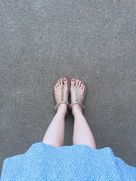 Female Feet Wear Sandals and Blue Dress on the Street