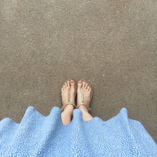 女脚穿凉鞋和蓝色礼服在街道上 — 图库照片