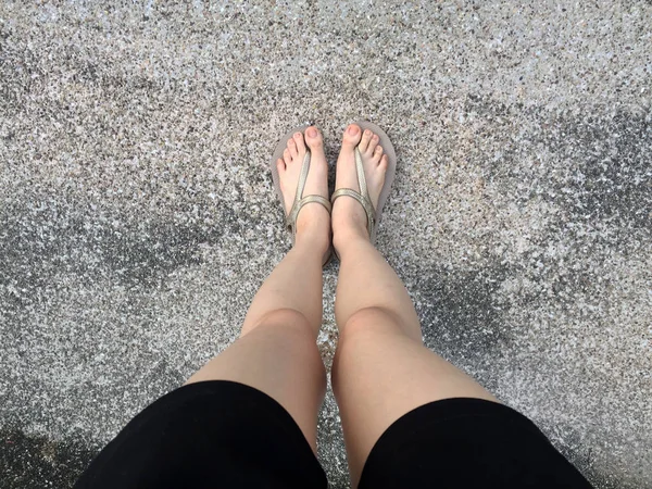 Altın sandalet ve siyah pantolon sokakta kadın ayakları — Stok fotoğraf