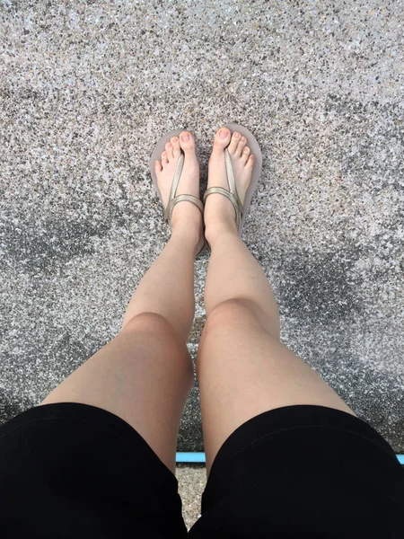 Жіночі ноги в золотих сандалі і чорні штани на вулиці — стокове фото