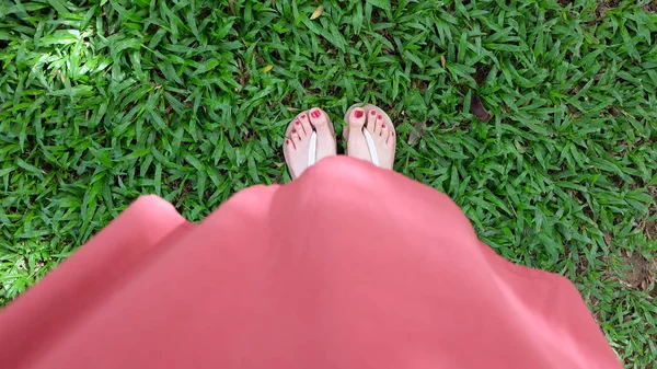 De cerca en los pies de la muchacha con sandalias sobre hierba verde — Foto de Stock