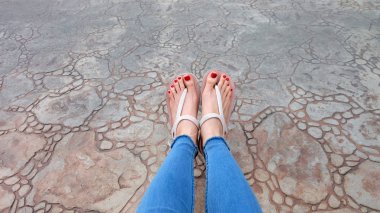 Kutunun üzerinde sandalet ve kot giyen kızın ayakları üzerinde Kapat