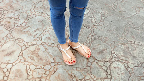 Close Up sui piedi della ragazza indossando sandali e Blue Jeans sulla piastrella — Foto Stock