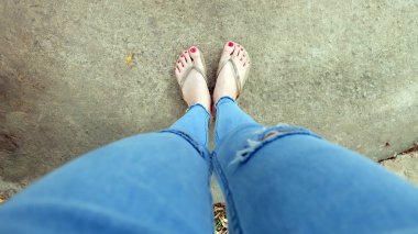 Beton zemin üzerinde sandalet giyen kadın