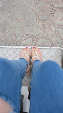 Ayak Selfie döşeme arka planı üzerinde duran altın sandaletler içinde